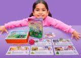 Criança com o livro-jogo das Letrinhas Mágicas brincando de esconde-esconde com a gatinha Trapi